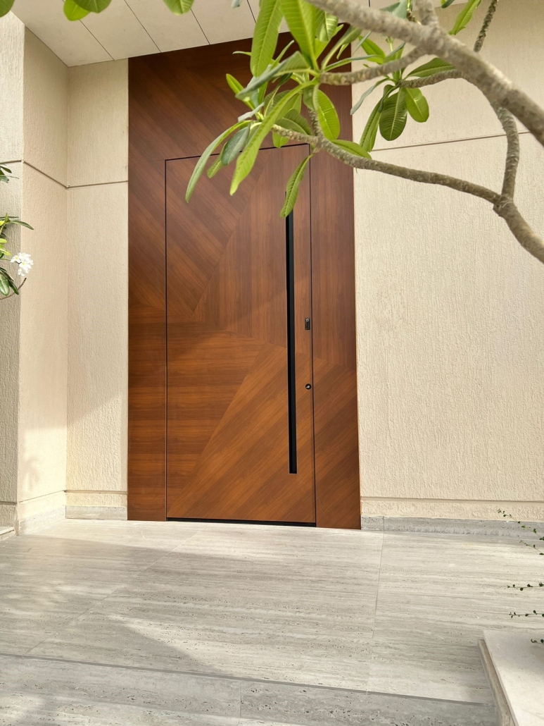 Front door in a wood finish with asymmetrical design lines, a recessed handle, an overdoor panel and a sidelight