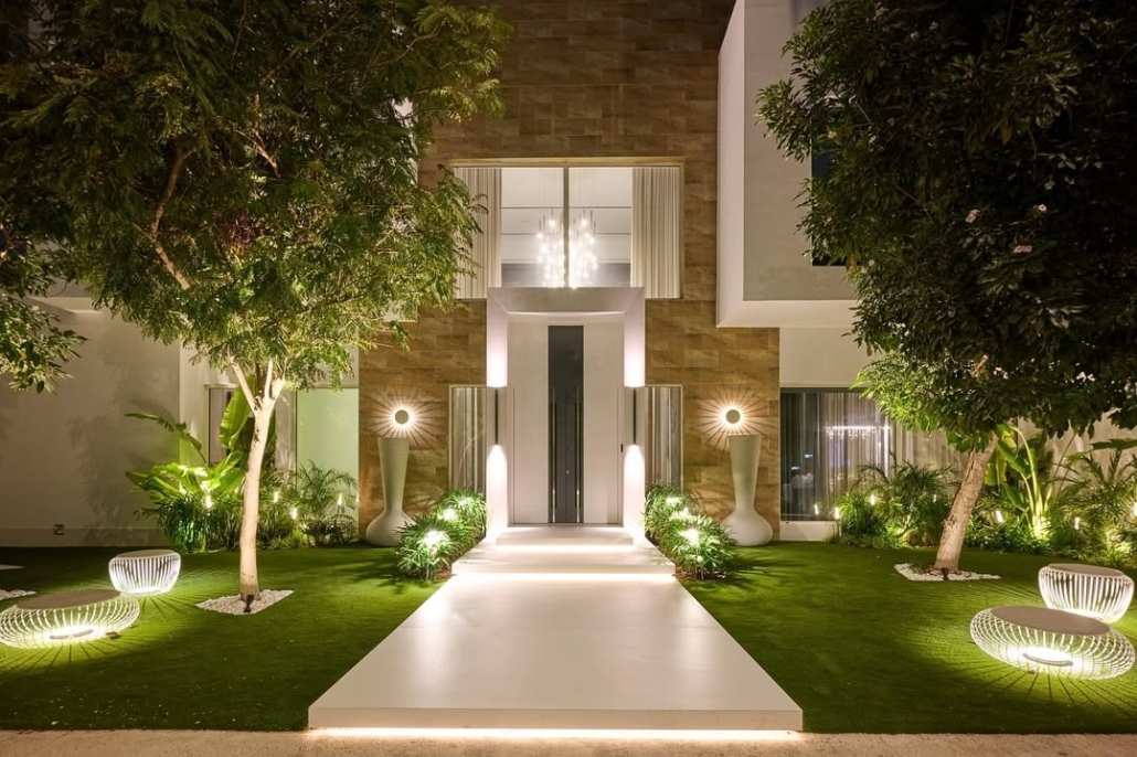 Mediterranean-style house with landscaped surroundings and a large white and grey front door