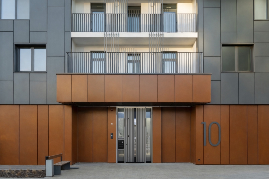 Modern multi-family residential building with grey entrance doors