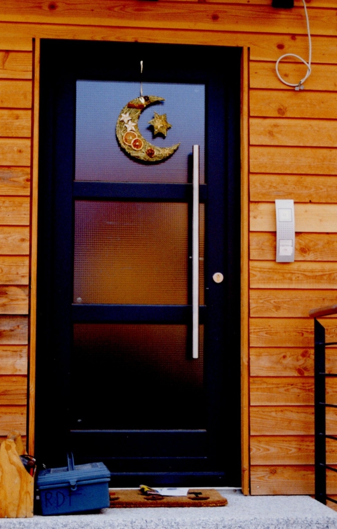 Old image of a black door with glass on a wooden façade
